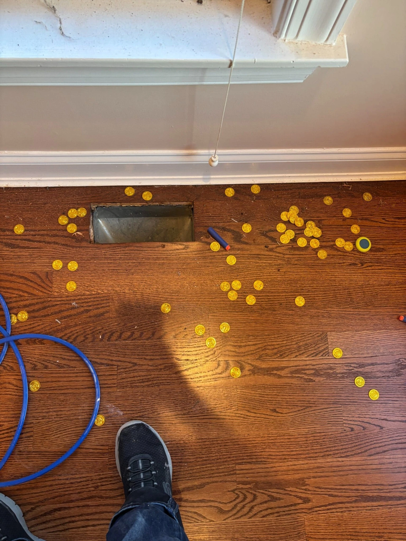 Air duct cleaning in North Brunswick NJ showing toy coins around floor vent opening, that were found inside the vent.