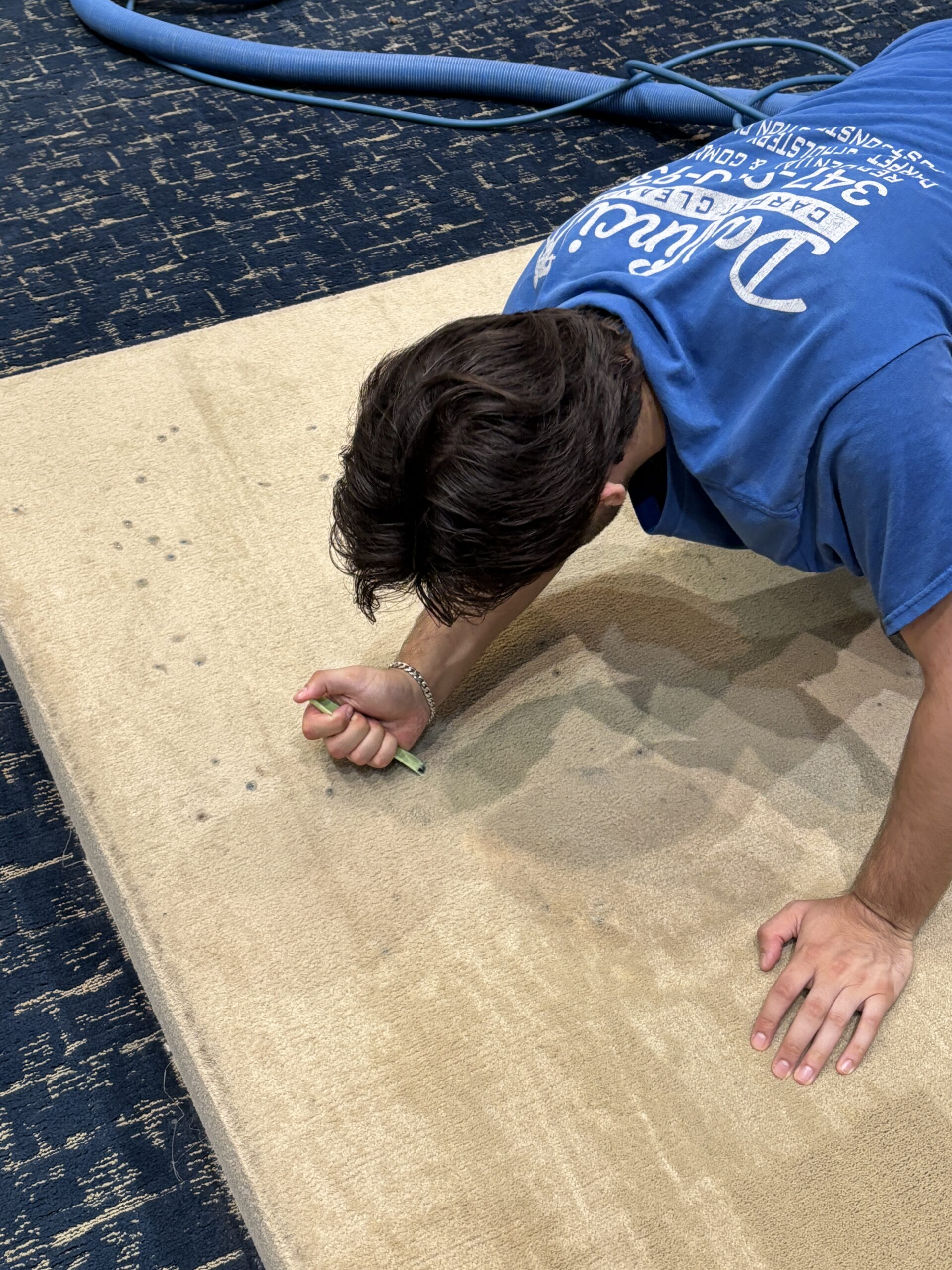 Technician scraping candle wax from carpet during emergency spot removal in Staten Island, NY.