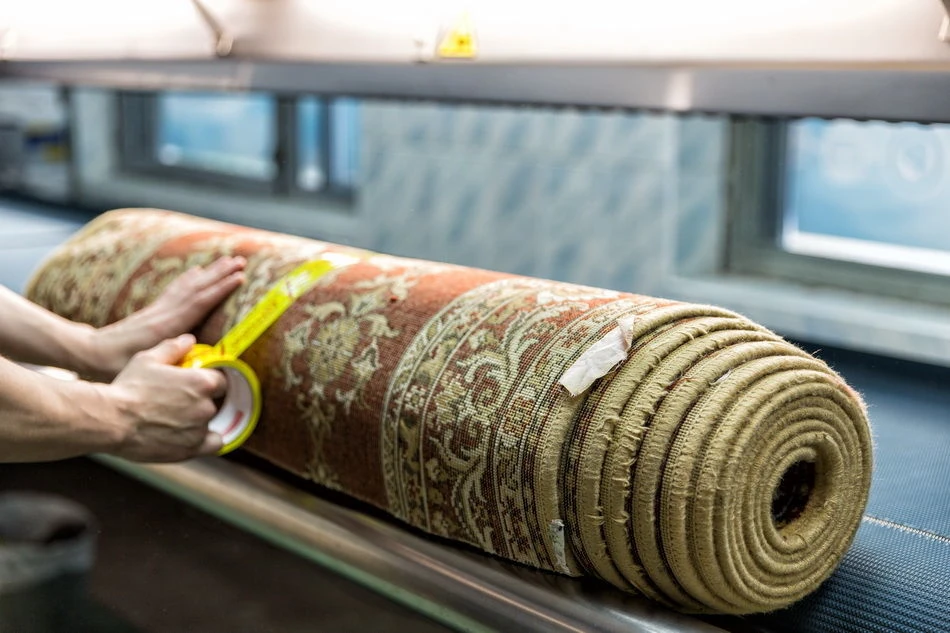 Rolled area rug inspection before off site cleaning in Staten Island NY