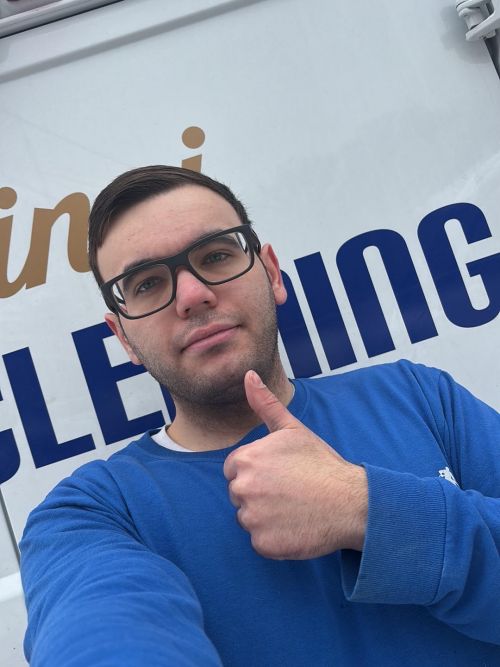 Michael from DaVinci Carpet Cleaning giving a thumbs up in front of company van.